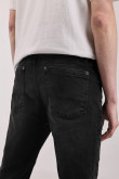 Jean skinny tiro bajo negro con botón metálico en la cintura