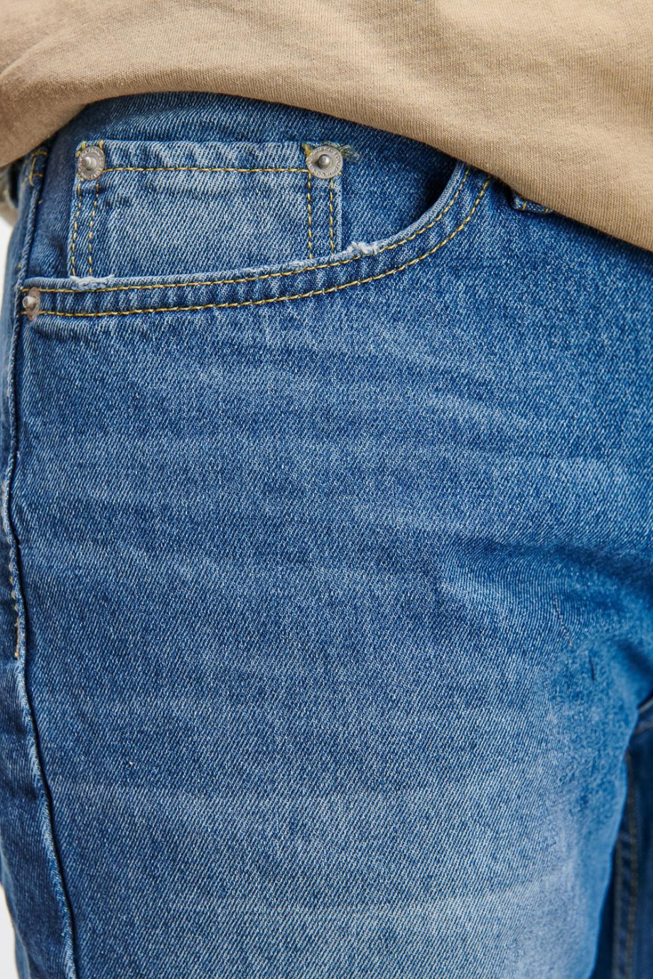 Jean 90´S azul medio tiro bajo con desgastes de color y 5 bolsillos