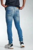 Jean súper skinny azul con desgastes, bolsillos y tiro bajo