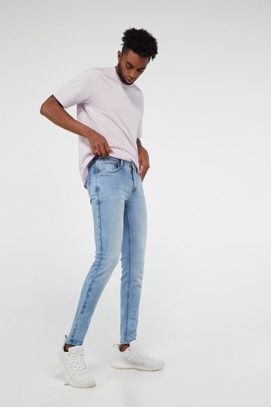 Jean skinny azul medio con costuras en contraste y desgastes de color