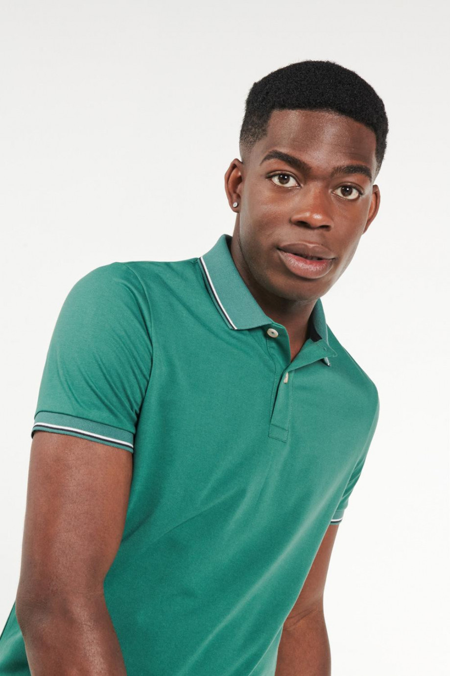 Camiseta polo verde oscura con líneas en puños y cuello
