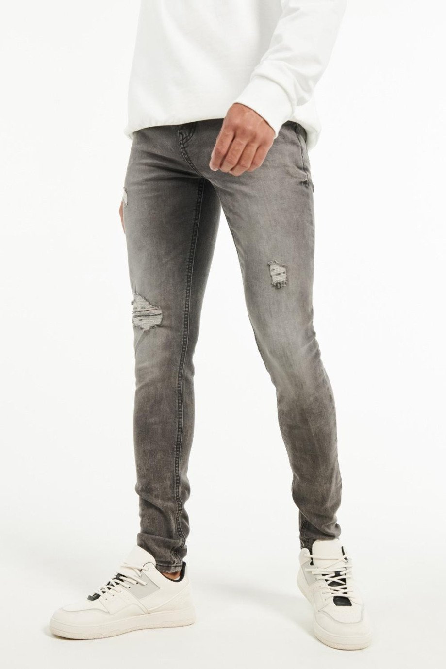 Jean gris oscuro súper skinny con desgastes de color y rotos