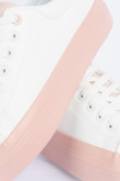 Tenis planos blancos con suelas rosadas en contraste
