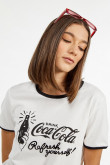 Camiseta crema manga corta con diseño negro de Coca-Cola