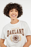 Camiseta crema clara crop top con estampado college de Oakland en frente