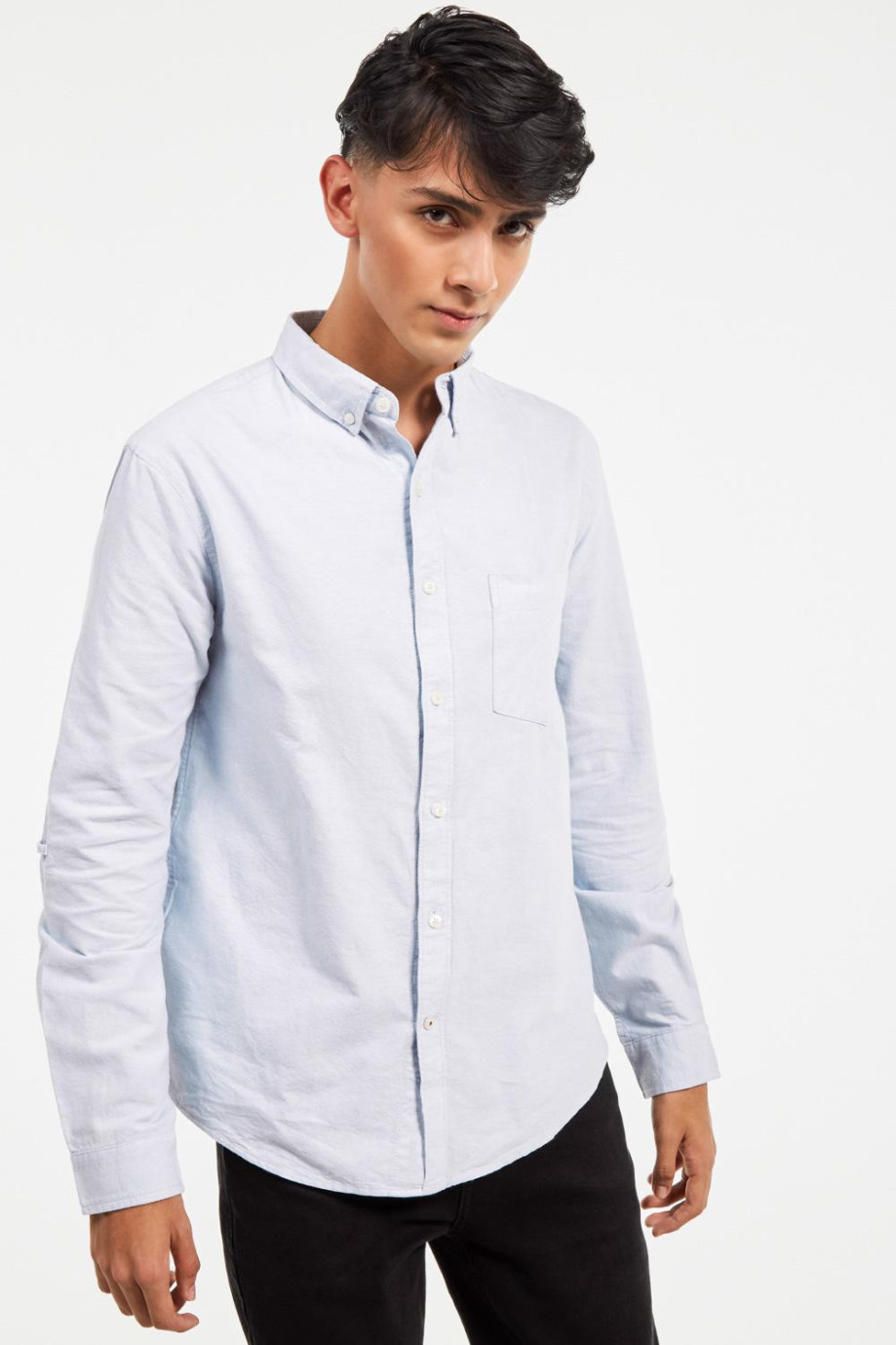 Camisa cuello button down, manga larga con bolsillo sobrepuesto en el frente de la camisa.