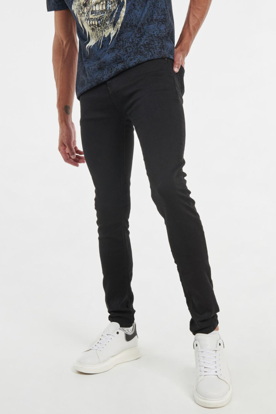 Jean negro súper skinny con tiro bajo, ajuste ceñido y botón metálico
