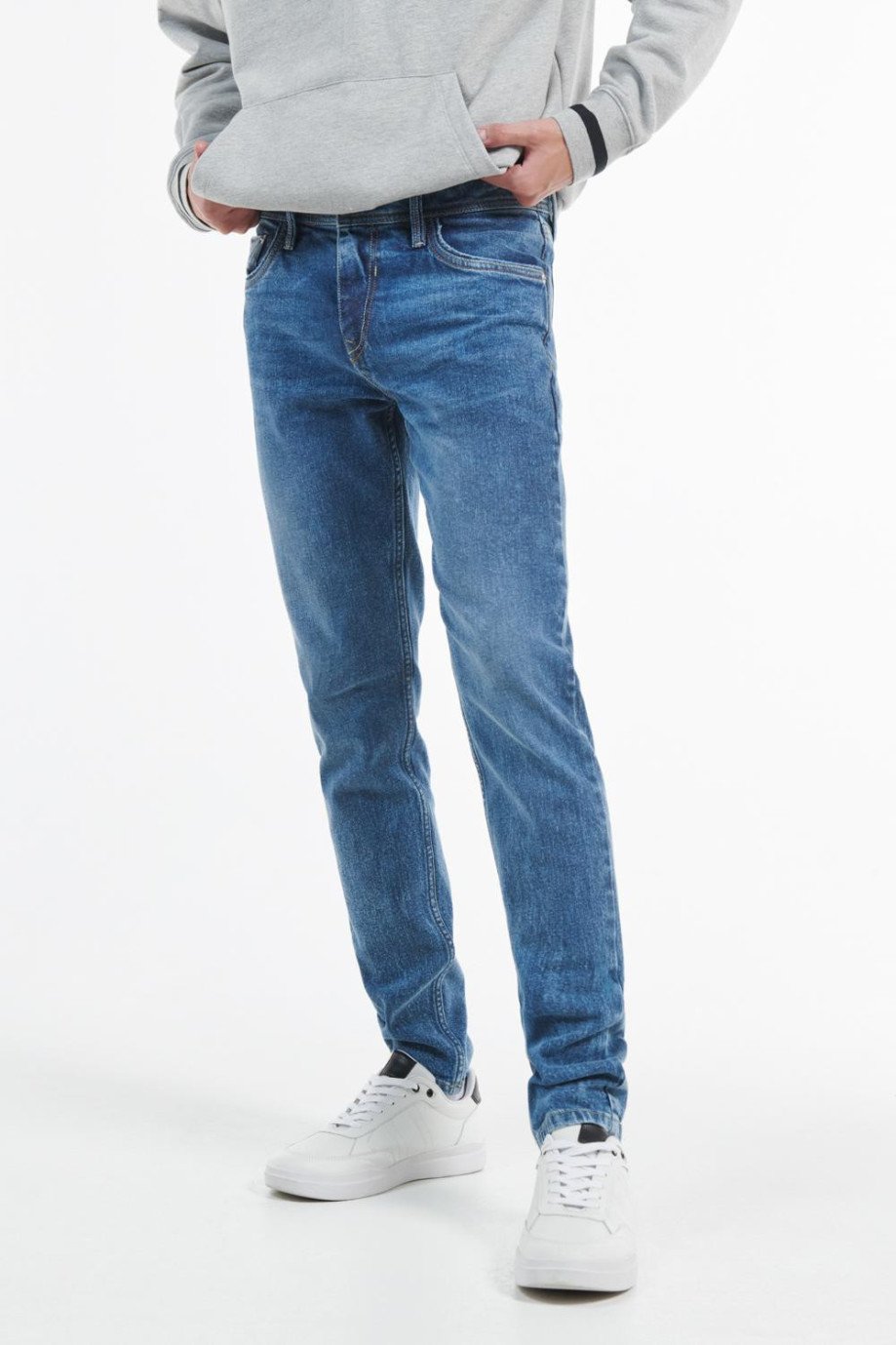 Jean azul medio skinny con desgastes de color, ajuste ceñido y tiro bajo