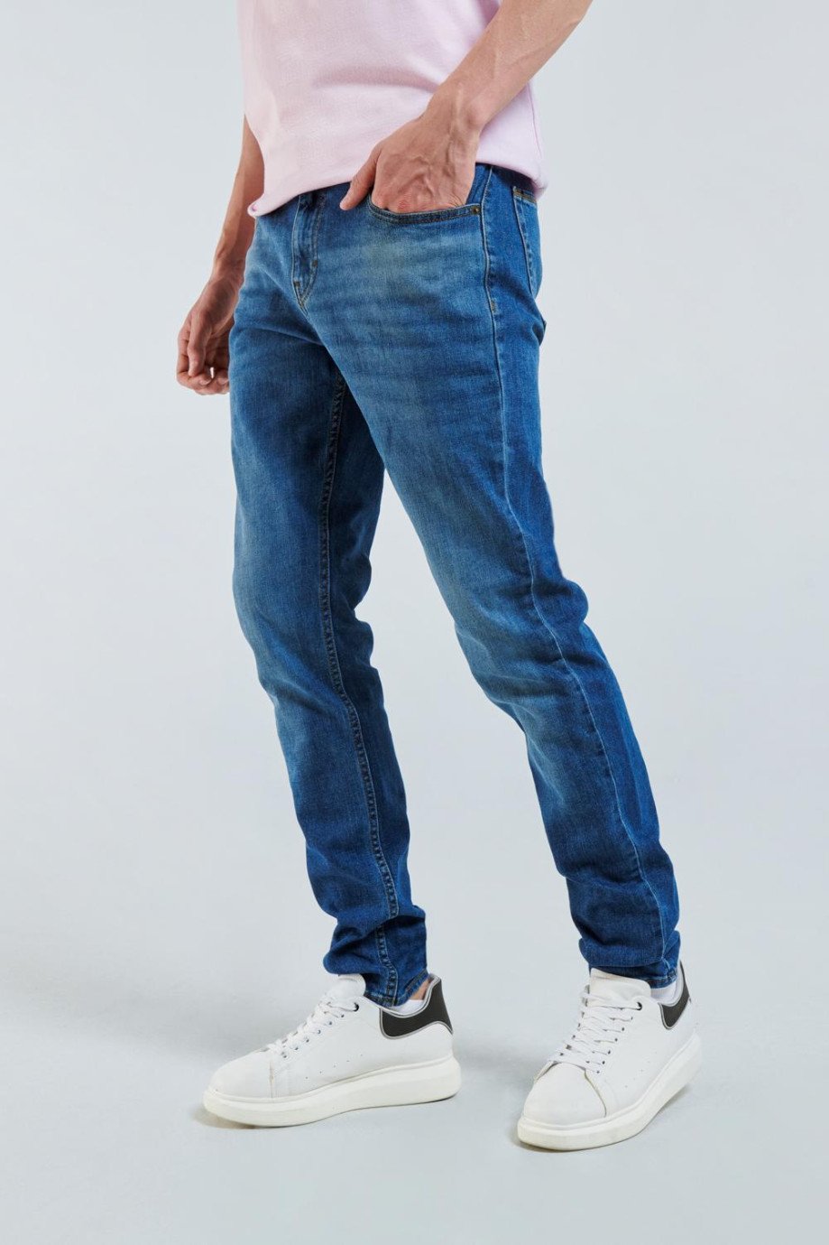 Jean slim azul con desgastes de color, tiro bajo y bolsillos