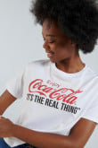 Camiseta crop top blanca con diseño de Coca-Cola y manga corta