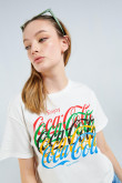 Camiseta crop top crema clara con cuello redondo y diseño de Coca-Cola