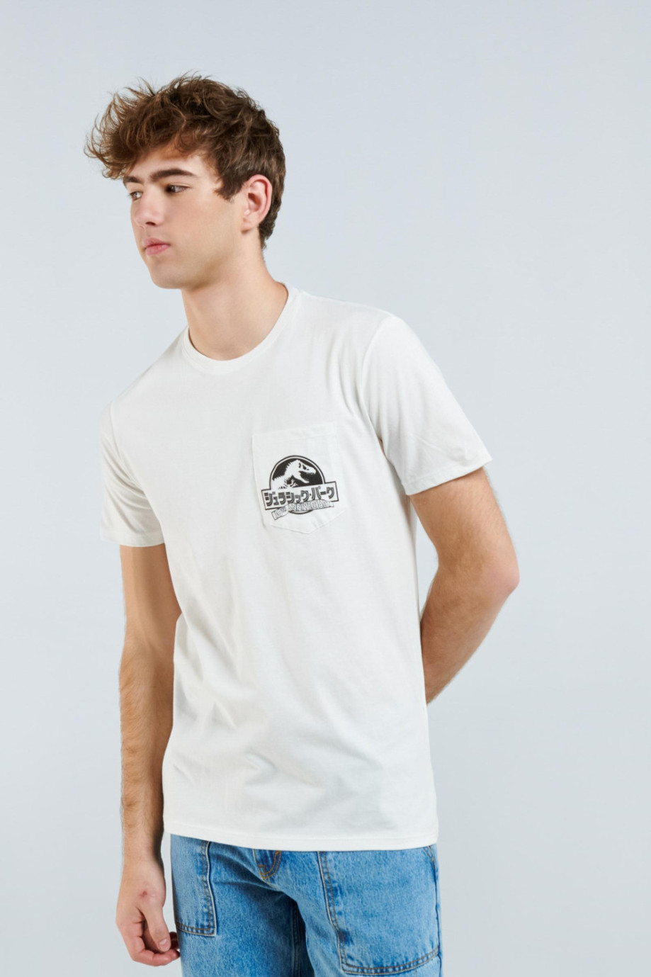 Camiseta crema clara con diseño de Jurassic Park, bolsillo y cuello redondo
