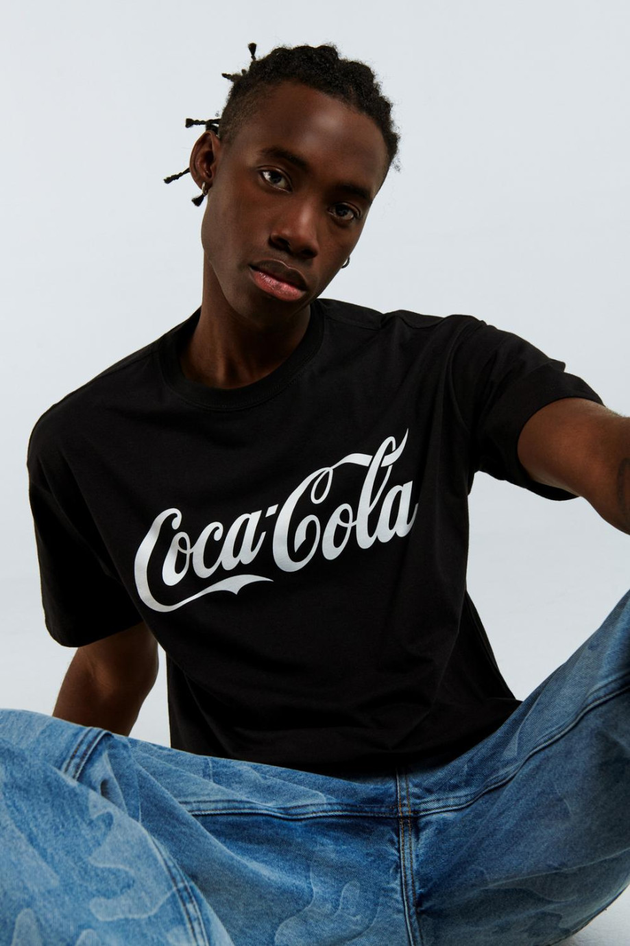 Camiseta cuello redondo negra con diseño blanco de Coca-Cola