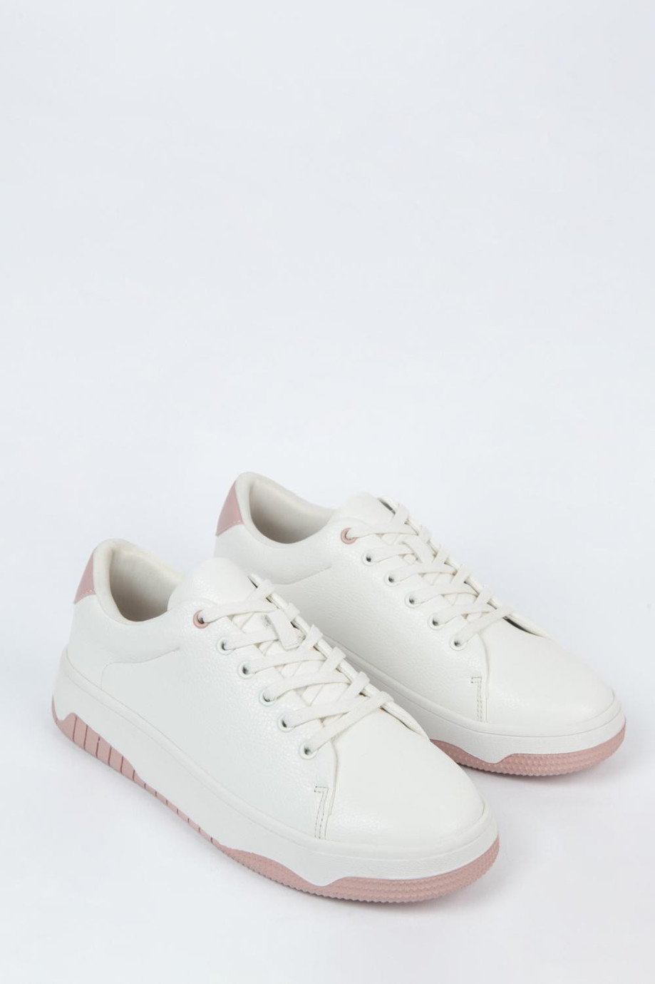 Tenis blancos casuales con suela plana y contrastes rosados