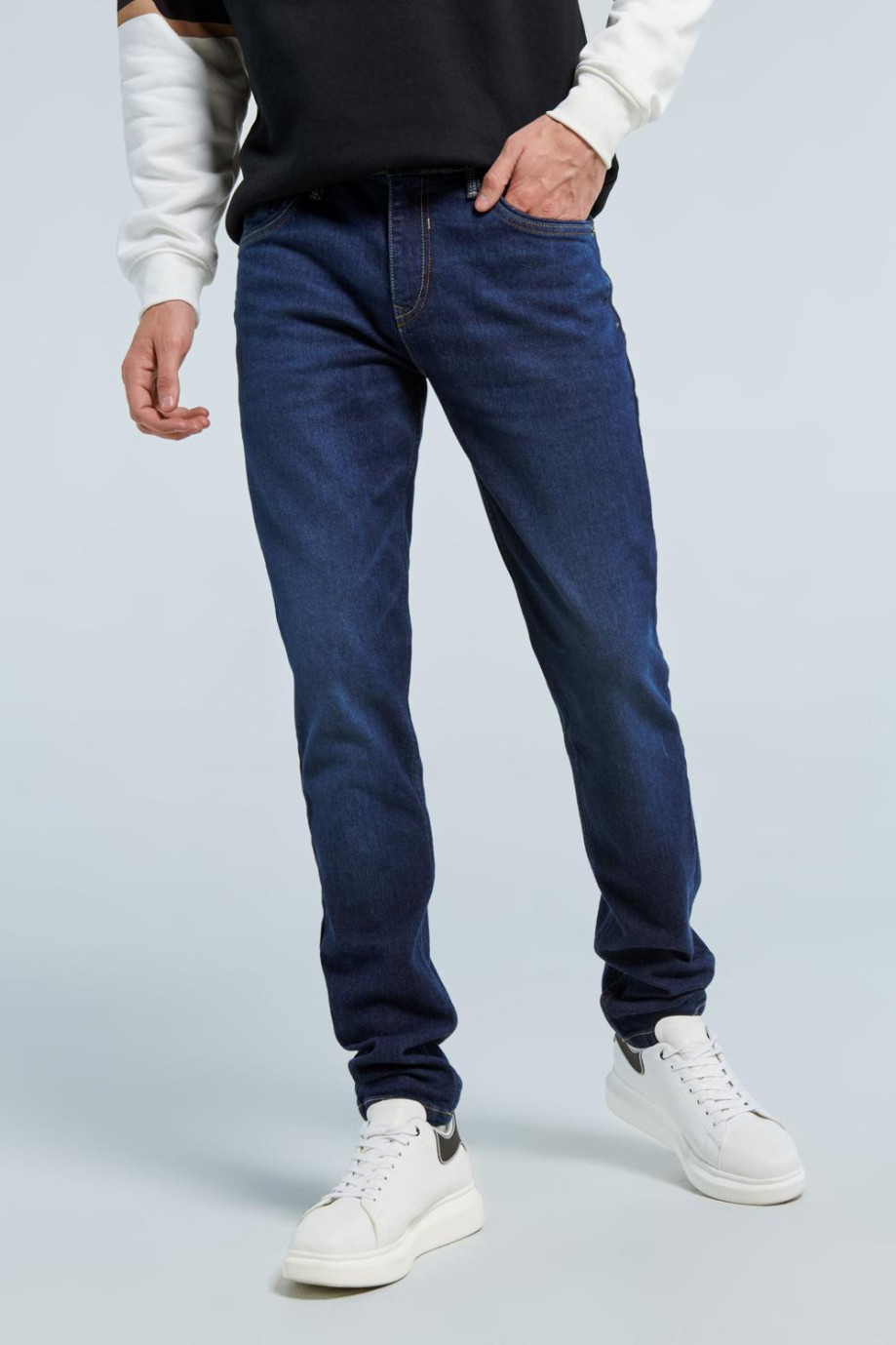 Jean skinny azul oscuro con ajuste ceñido, bolsillos y costuras cafés