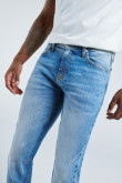 Jean azul medio slim con desgastes sutiles y 5 bolsillos