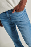 Jean slim azul claro con desgastes, bolsillos y tiro bajo