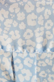 Blusa azul clara con cuello camisero, manga 3/4 y diseños de flores blancas