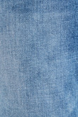Jean slim azul claro con tiro bajo y desgastes de color localizados