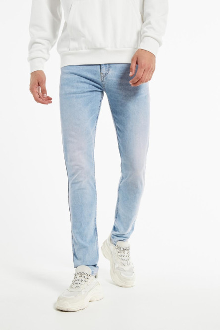 Jean súper skinny azul con desgastes de color y tiro bajo