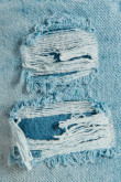 Short tiro alto en jean azul claro con rotos en frente y desgastes de color