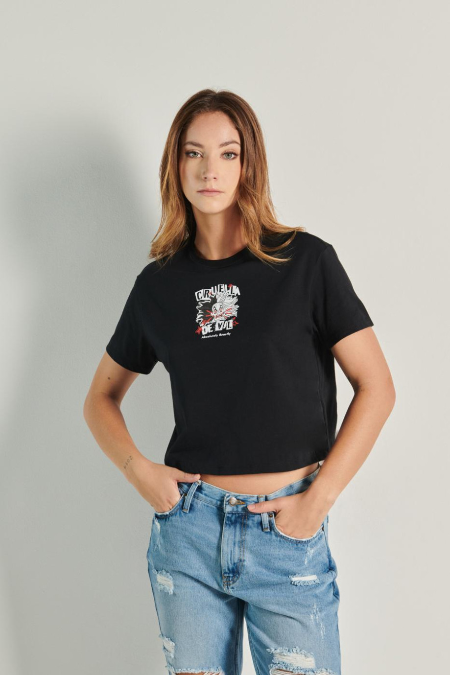Camiseta negra crop top con arte de Cruella de Vil en frente