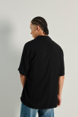 Camisa negra con cuello sport collar y diseños blancos