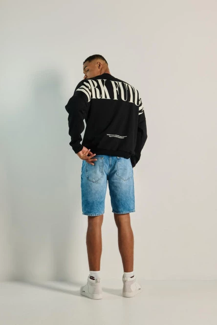 Buzo negro oversize con texto posterior y cuello redondo