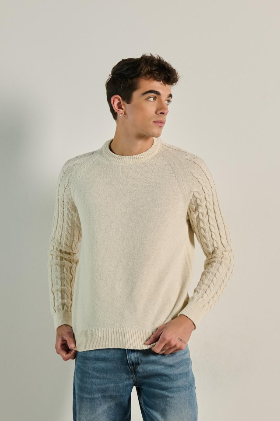 Suéter crema claro con texturas de trenzas y cuello redondo