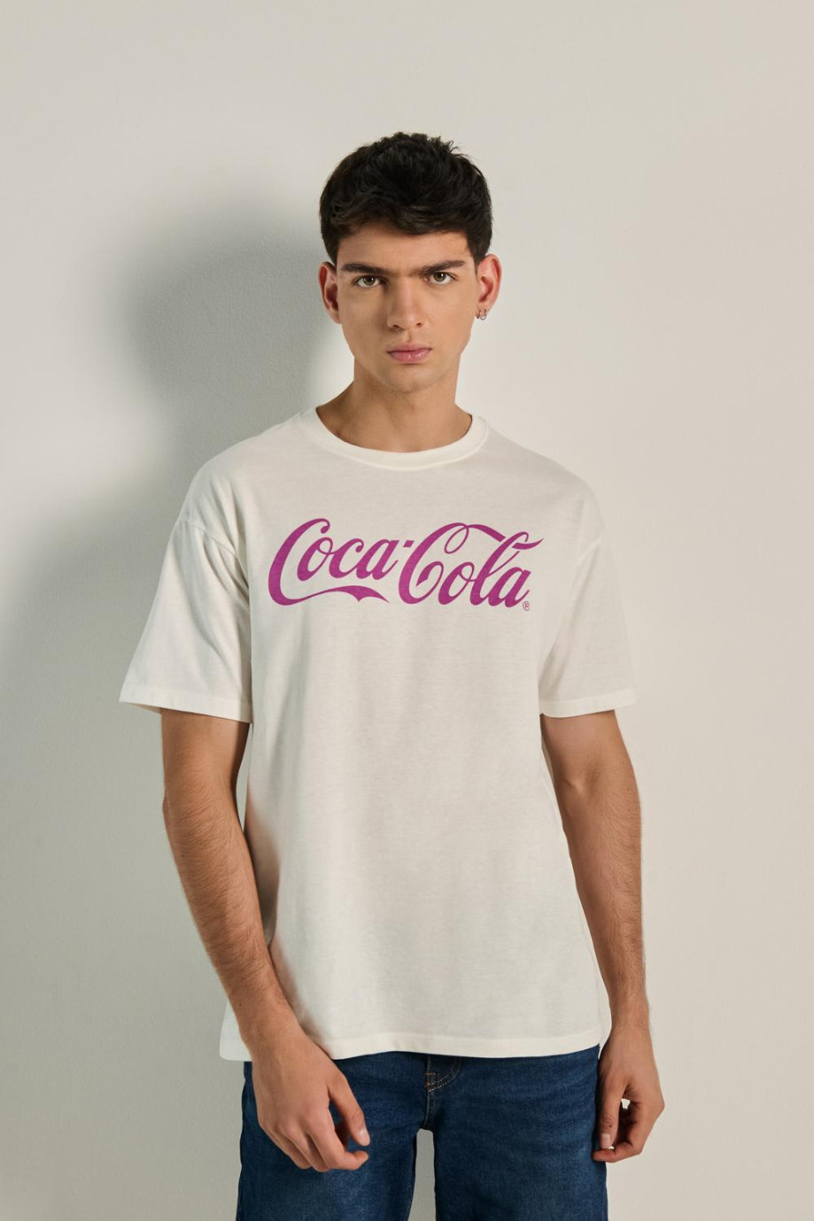 Camiseta crema oversize manga corta con texto de Coca-Cola