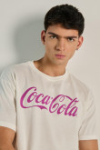 Camiseta crema clara manga corta con texto de Coca-Cola