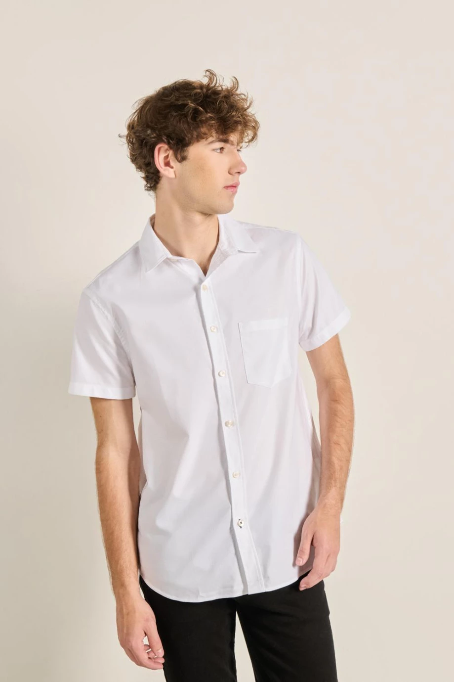 Camisa manga corta unicolor con cuello sport y bolsillo en frente