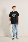 Camiseta oversize unicolor con texto college y manga corta