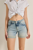 Short tiro medio en jean azul con desgastes y bolsillos