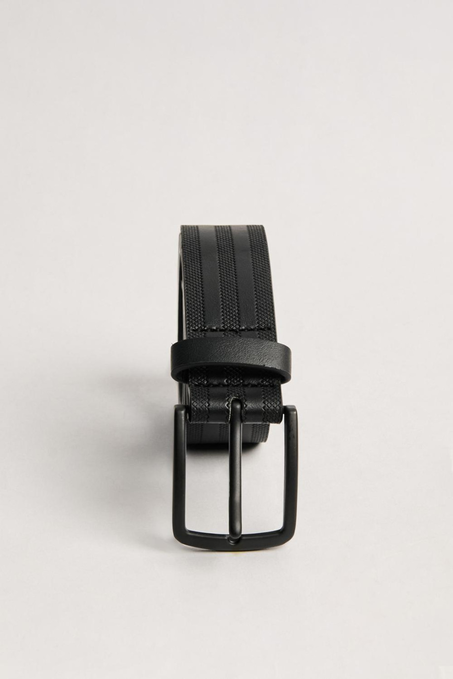 Cinturón negro con hebilla metálica y texturas de líneas
