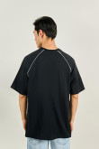 Camiseta oversize negra con texto college y manga ranglan