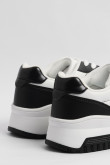 Tenis urbanos femeninos en color blanco con cortes en negro con una suela de plataforma de 3cm de altura.