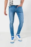 Jean skinny azul claro con desgastes localizados y tiro bajo