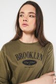 Camiseta verde crop top oversize con texto college negro