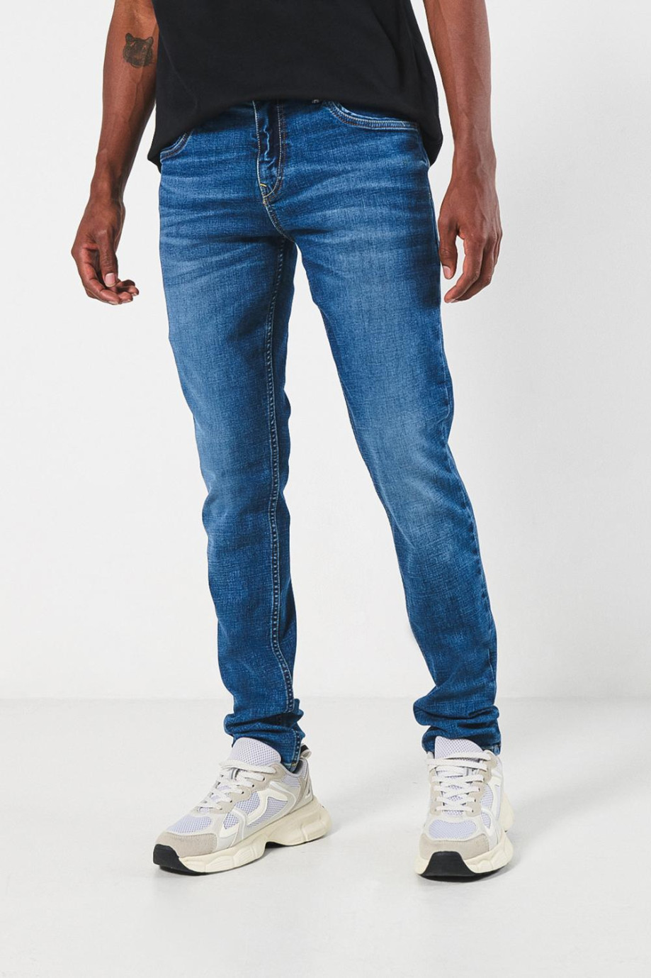 Jean skinny azul claro con desgastes localizados y tiro bajo