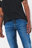 Jean skinny azul claro con desgastes localizados y tiro bajo