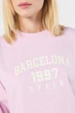 Buzo crop top rosado con texto college en frente