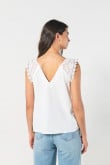 Blusa crema clara con escote en V y hombros en encaje