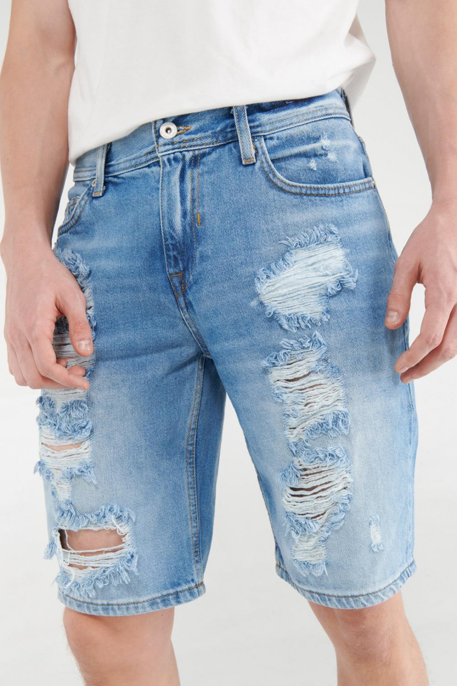 Bermuda azul medio en jean con diseños de rotos en frente