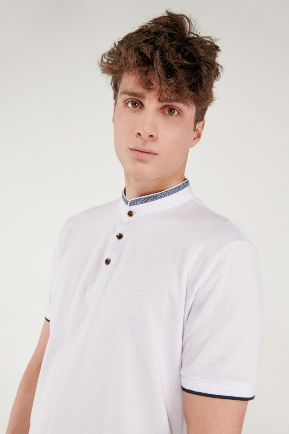 Camiseta Polo unicolor con cuello neru y puños tejidos.