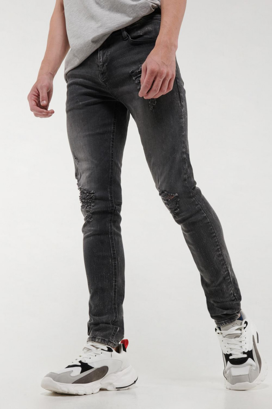 Jean súper skinny gris oscuro con rotos delanteros y desgastes de color