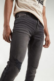 Jean skinny negro con tiro bajo y roto en pierna derecha